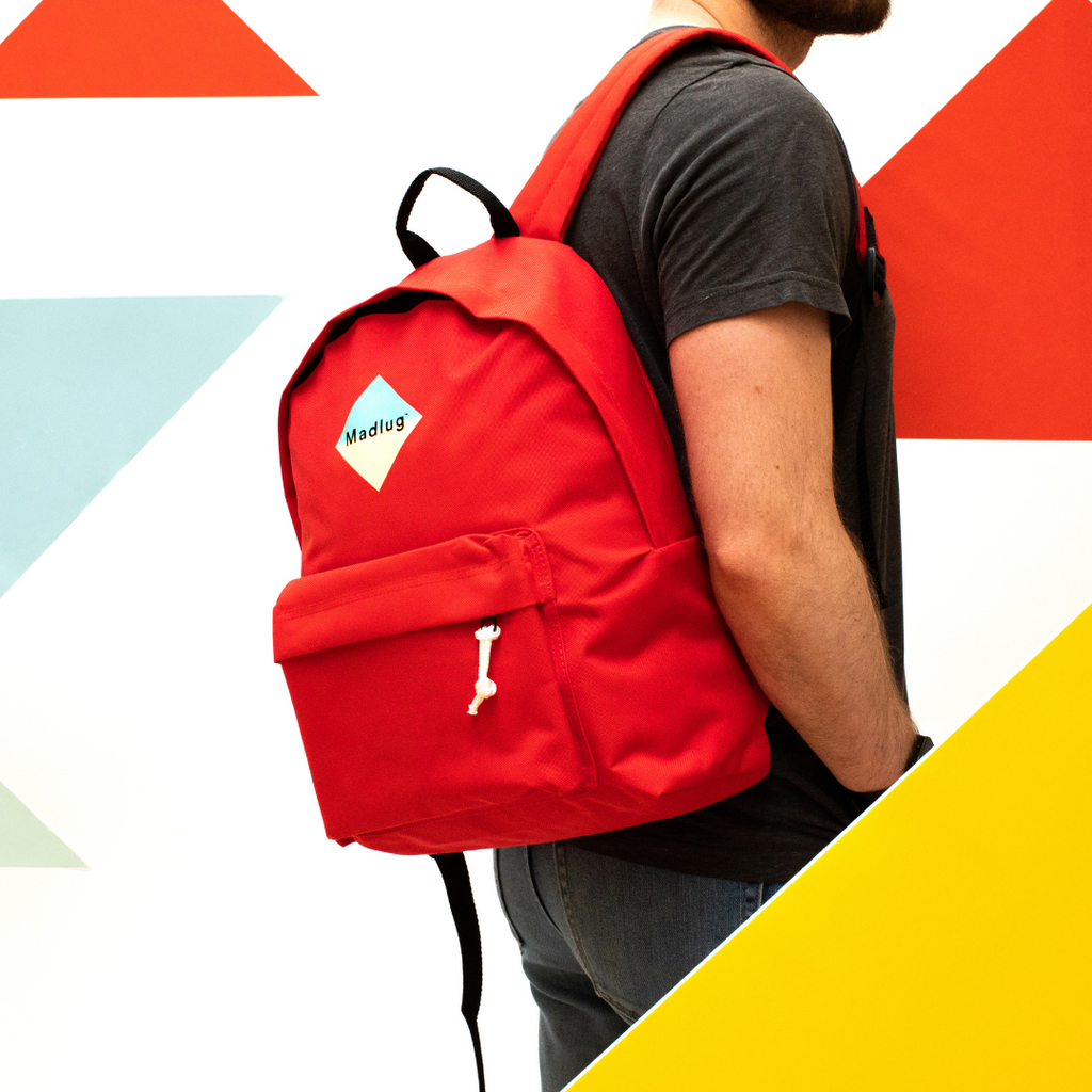 Madlug Classic Backpack in Red. Male model side view.