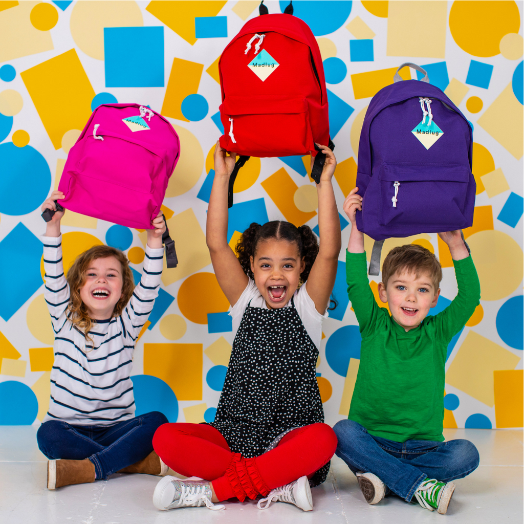 Madlug Junior Backpacks. Studio image with kids showing colour options.