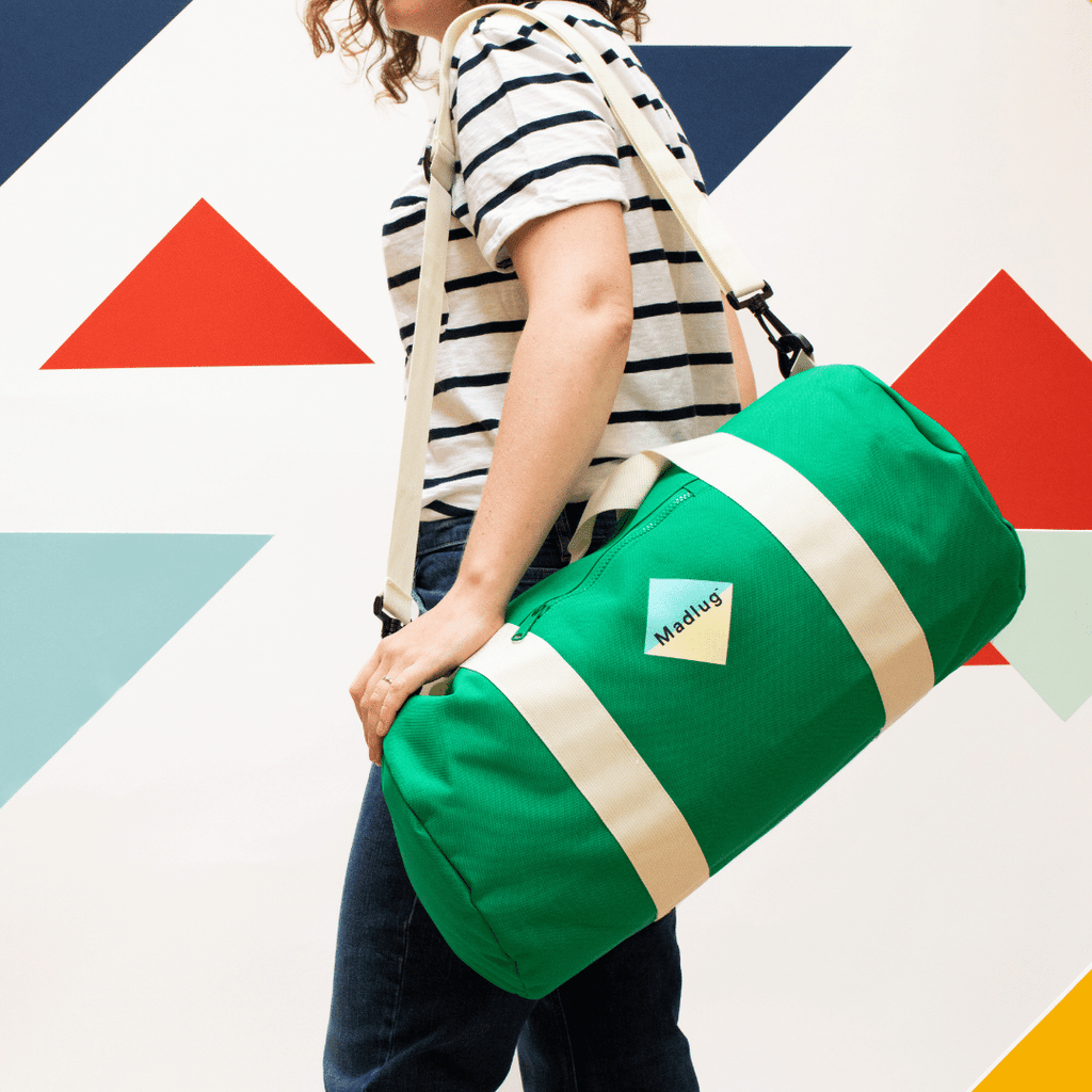 Madlug Duffel Bag in Green. Modelled showing side view.
