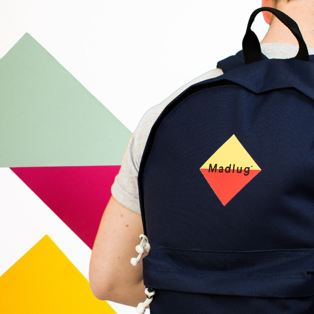 Madlug Classic Backpack in Navy. Male model side view.